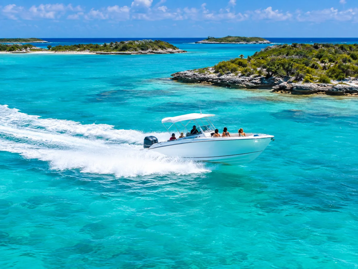 Powerboat crossing turquoise water between Exuma cays